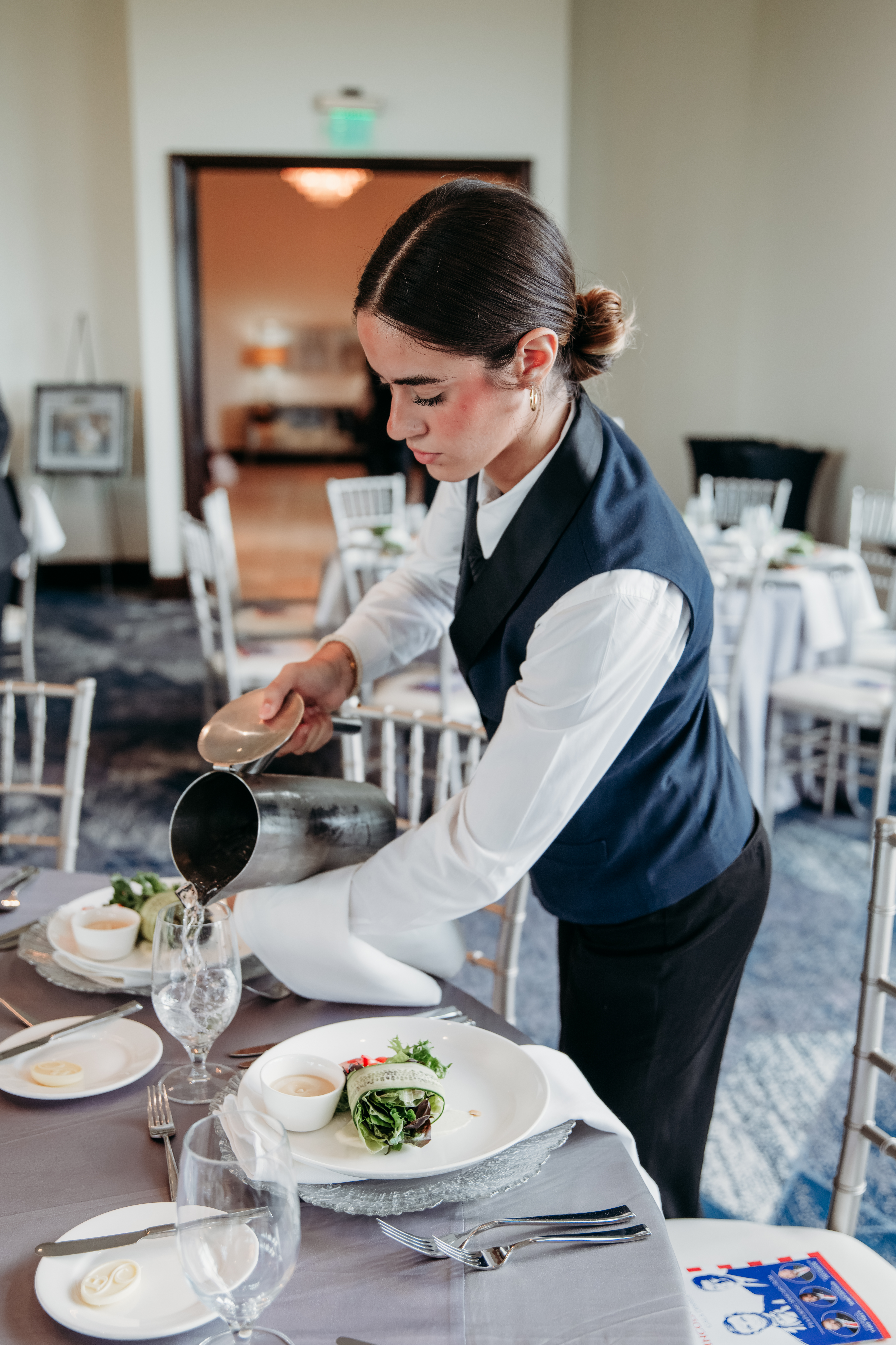 Bella Collina employee filling water glasses