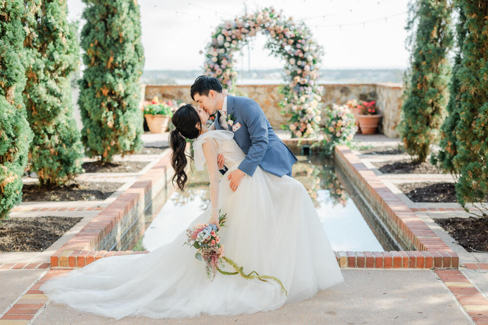 Bride and groom embracing at Bella Collina reflection pool