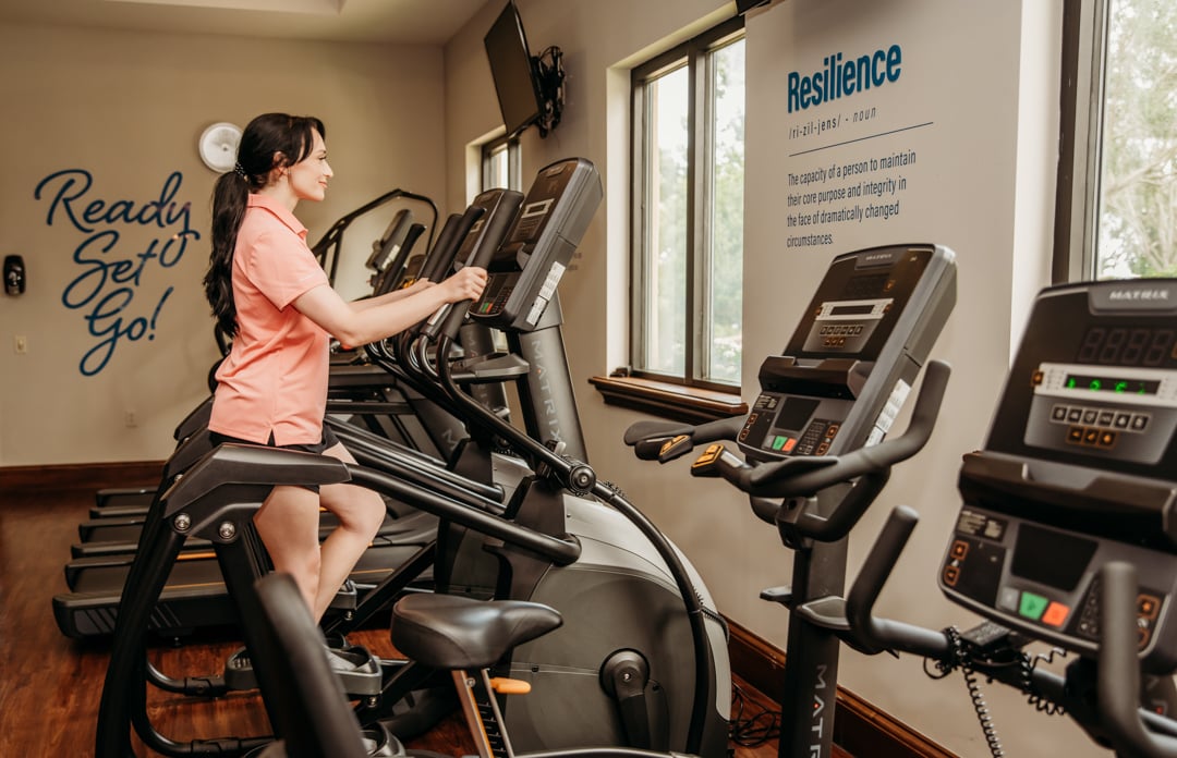 Woman on step machine at Bella Collina fitness center