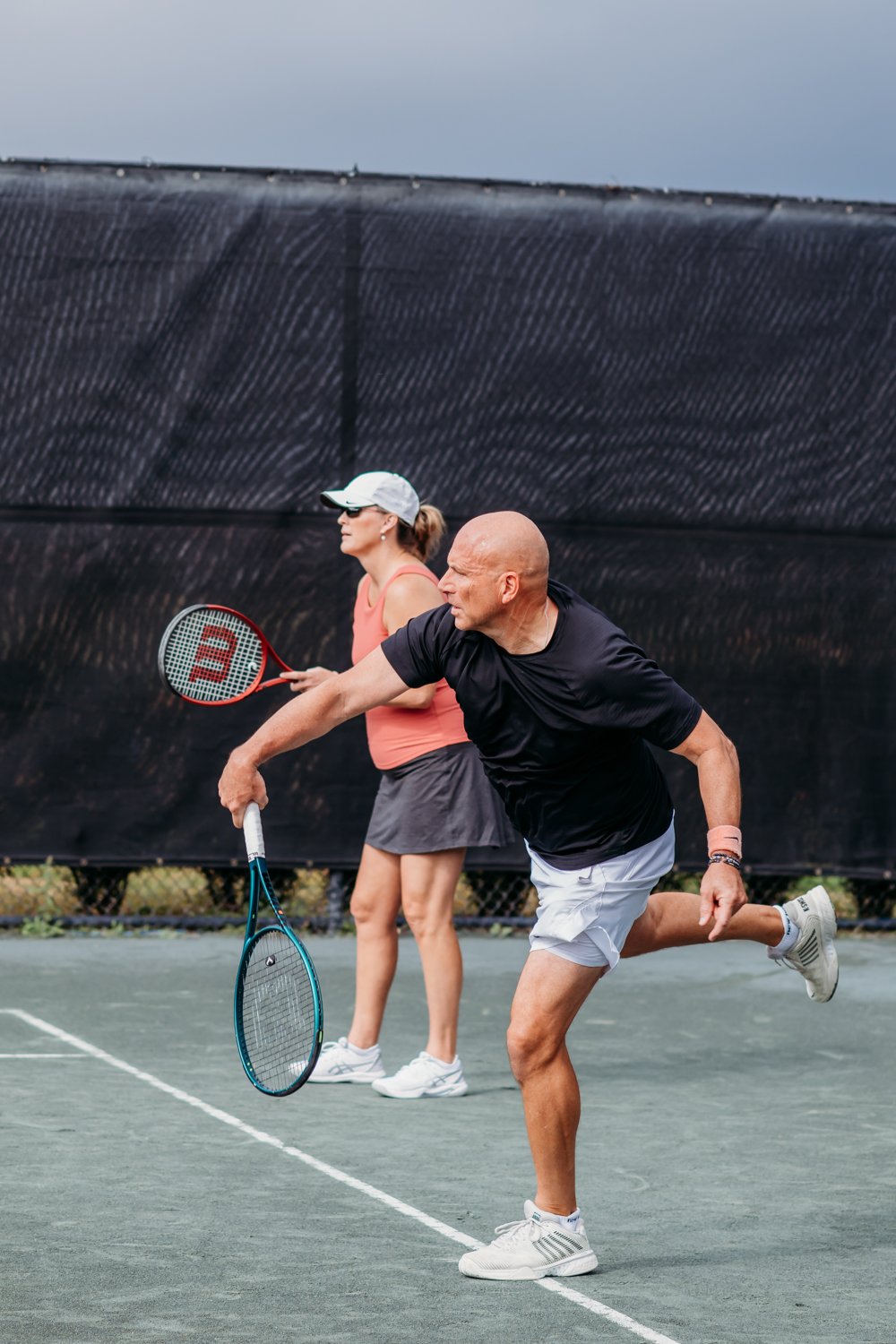 Man serving will playing couple tennis at Bella Collina