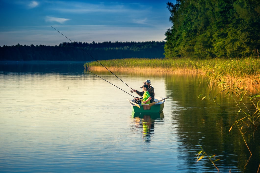 8 Benefits of Living in a Lakefront Home -  A father with his son fishing in the lake - Bella Collina
