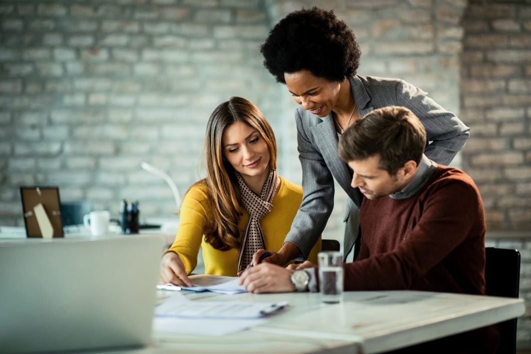 People closing a deal by signing documents