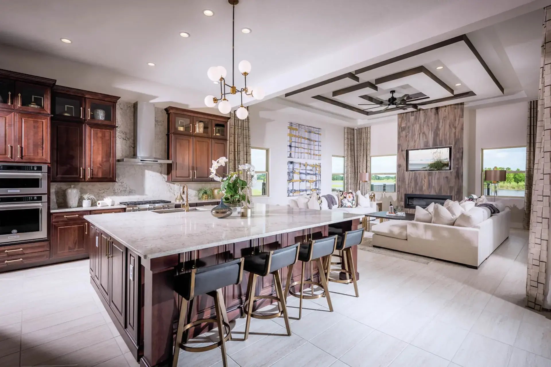 Luxury open-concept kitchen and living room with large island and bar seating in a Bella Collina home