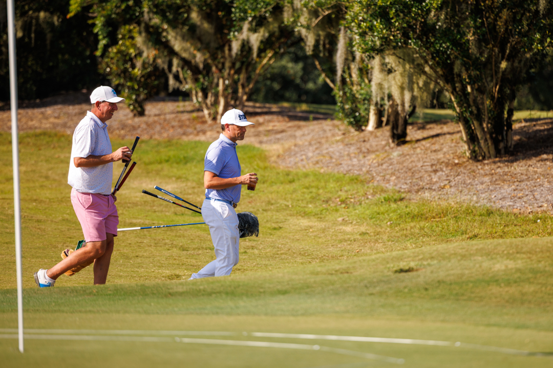Two men walking with clubs on Bella Collina golf course