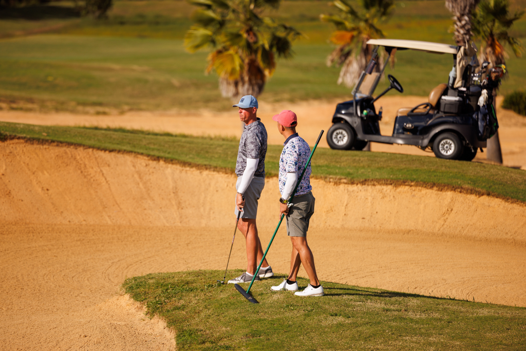 Two men standing by bunker at Bella Collina golf course