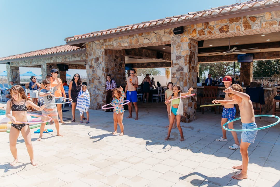 Kids doing hula hoops at Bella Collina pool