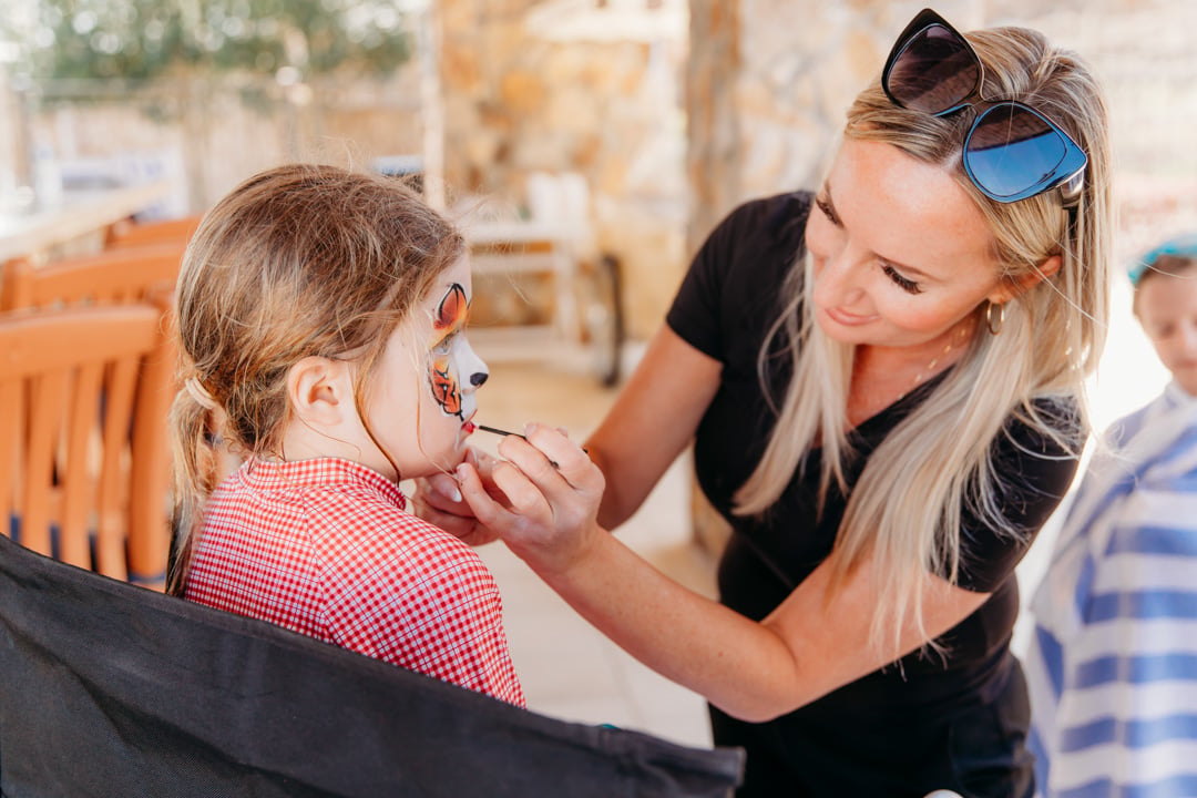Child getting face painted at Bella Collina member event