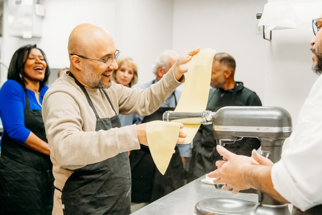 Group watching chef make pasta