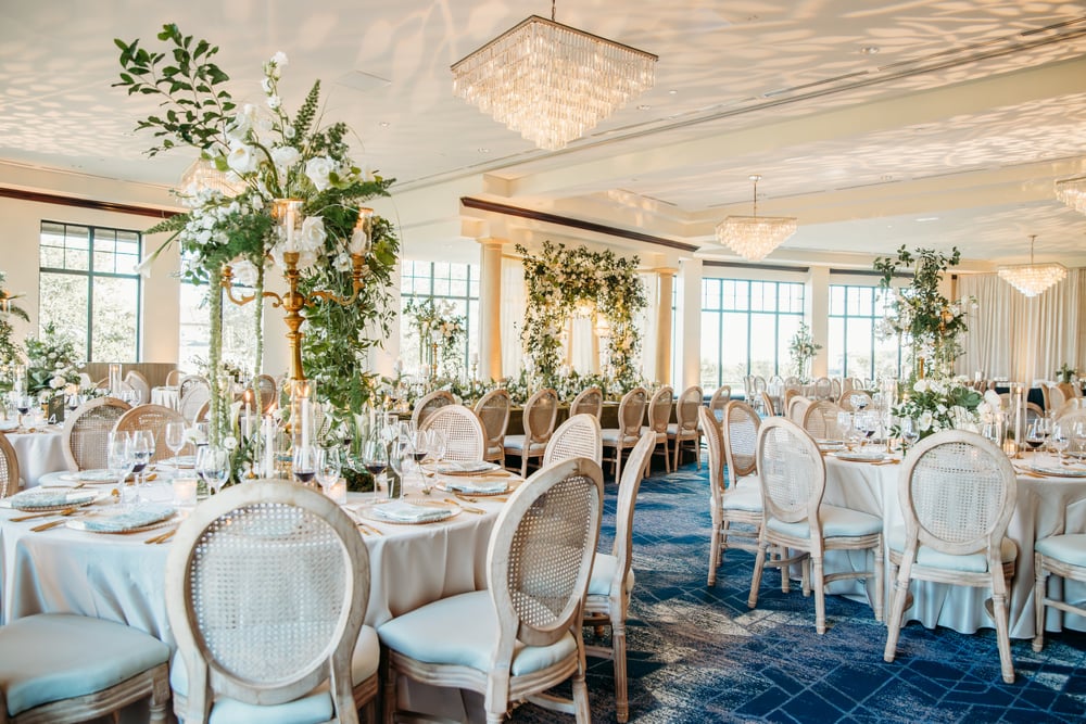 Dining setup with floral arrangements in the Ballroom at Bella Collina