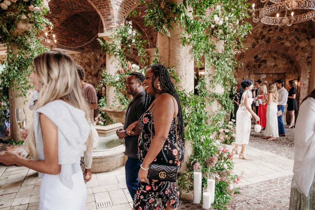 Guests mingle among lush floral displays in the Bella Collina atrium