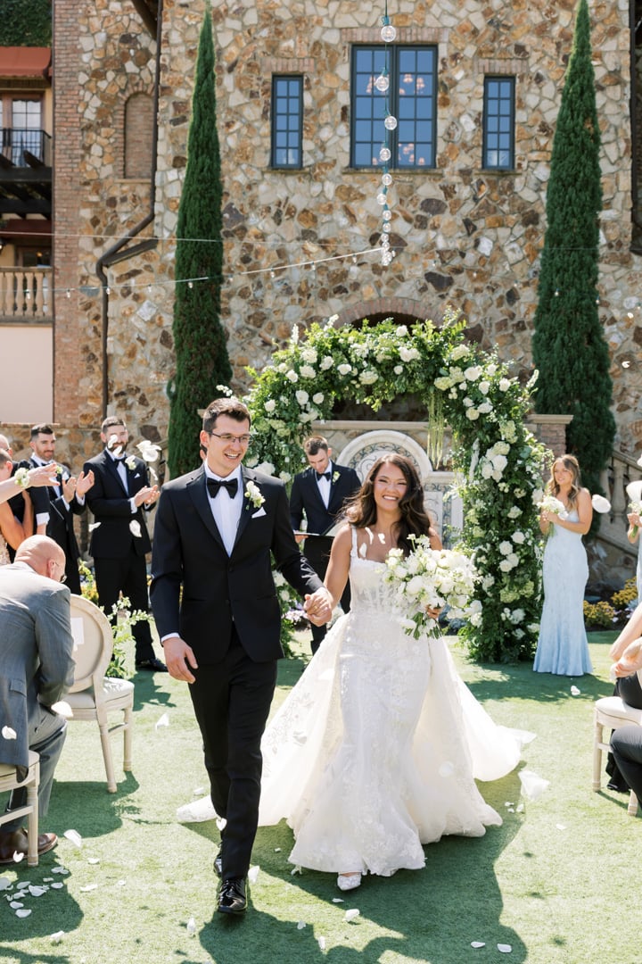 Newlywed couple walking down the aisle after an outdoor wedding ceremony at Bella Collina