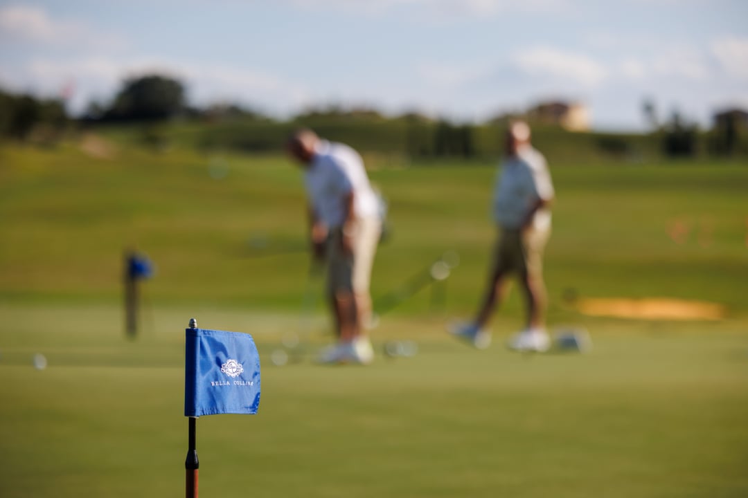 Players putting at Bella Collina Practice Facility