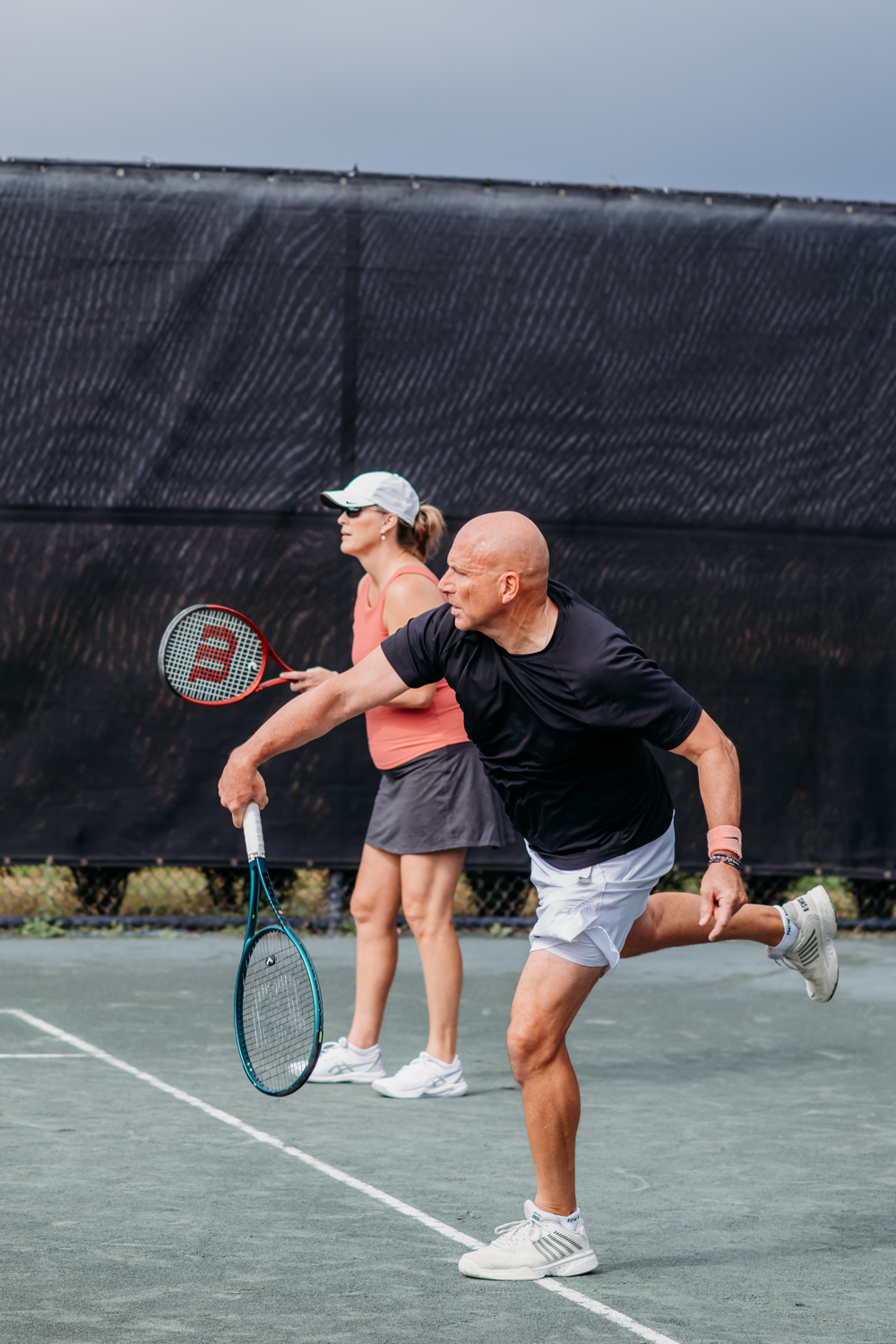 Man and woman playing tennis doubles at Bella Collina
