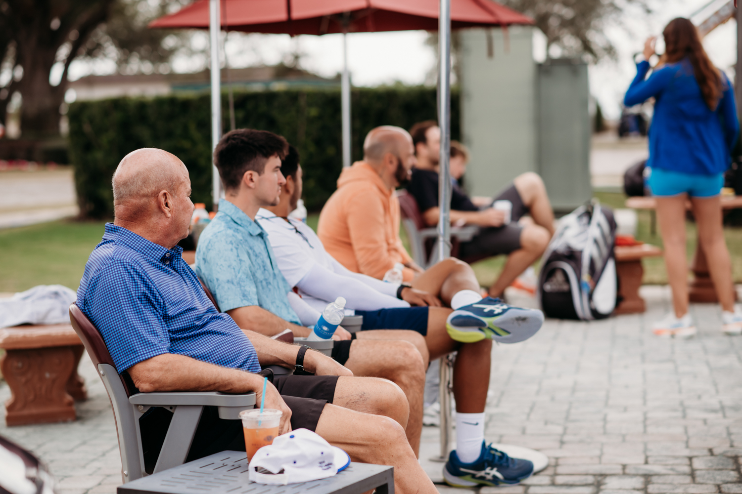 People sitting courtside at Bella Collina tennis courts