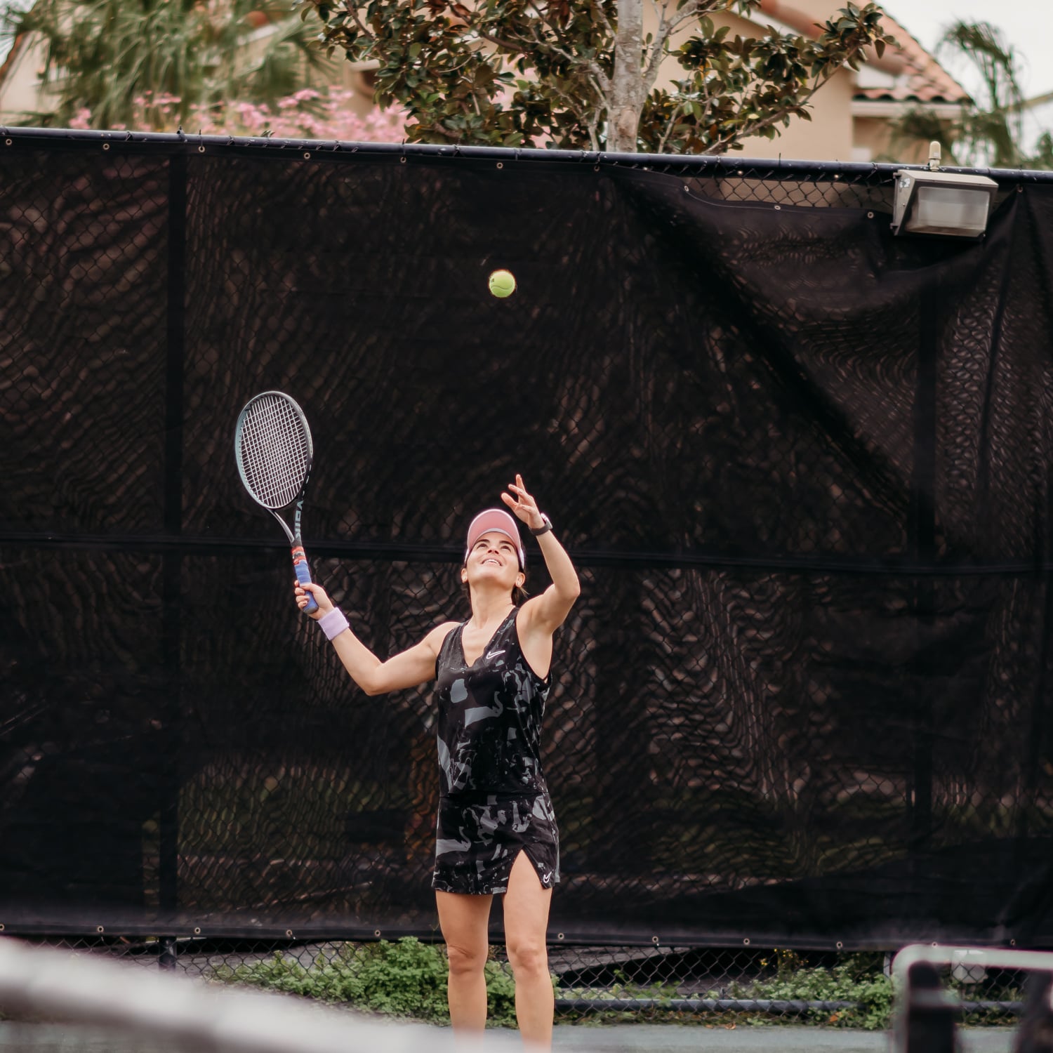 Woman serving during tennis match at Bella Collina
