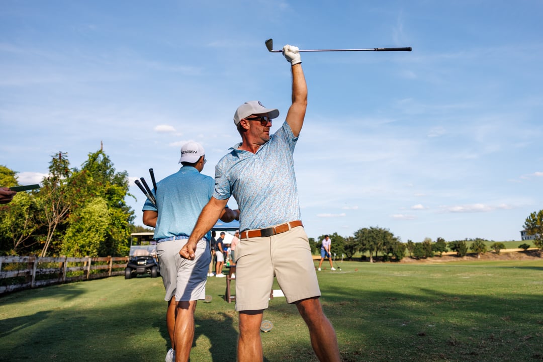 Man holding iron club in the air at Bella Collina golf course