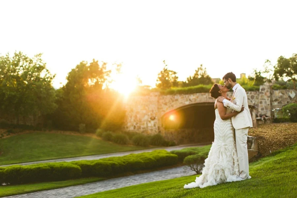 Bride and groom embracing on the lawn at sunset at Bella Collina