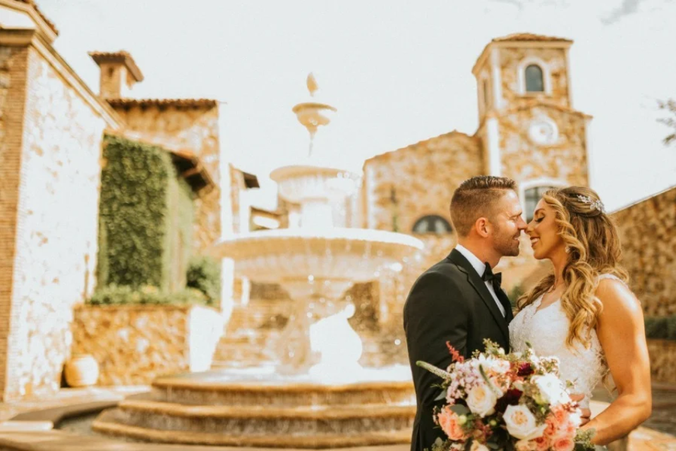 Bride and groom kissing beside the fountain at Bella Collina