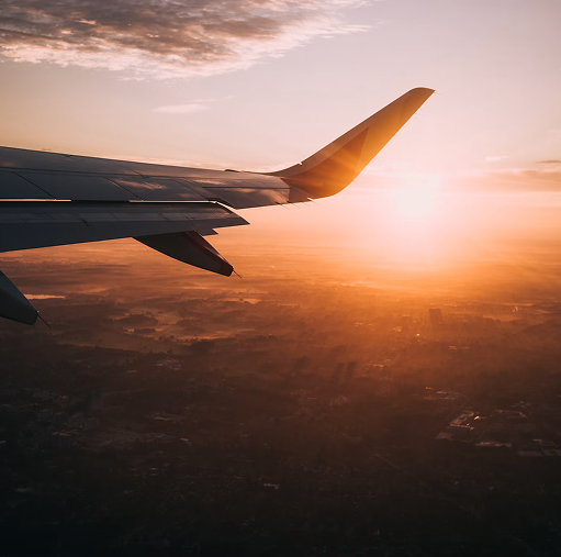 Aerial view of wing of plane flying over landscape