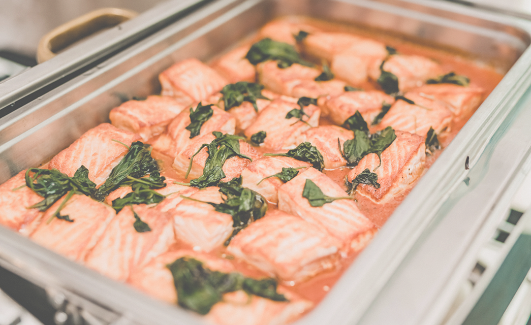 Baked salmon garnished with fresh herbs at Bella Collina wedding tasting event