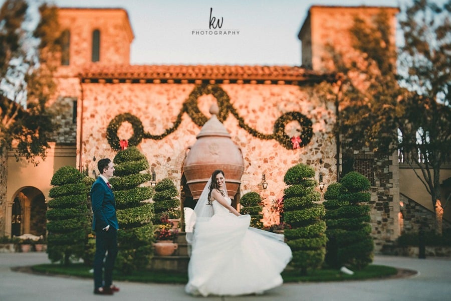 Bride and groom posing in front of the Clubhouse at Bella Collina