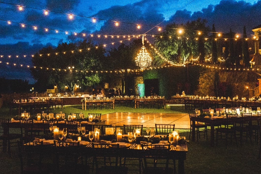 Evening Grand Lawn event with illuminated dance floor, string lights, and candlelit dining tables at Bella Collina
