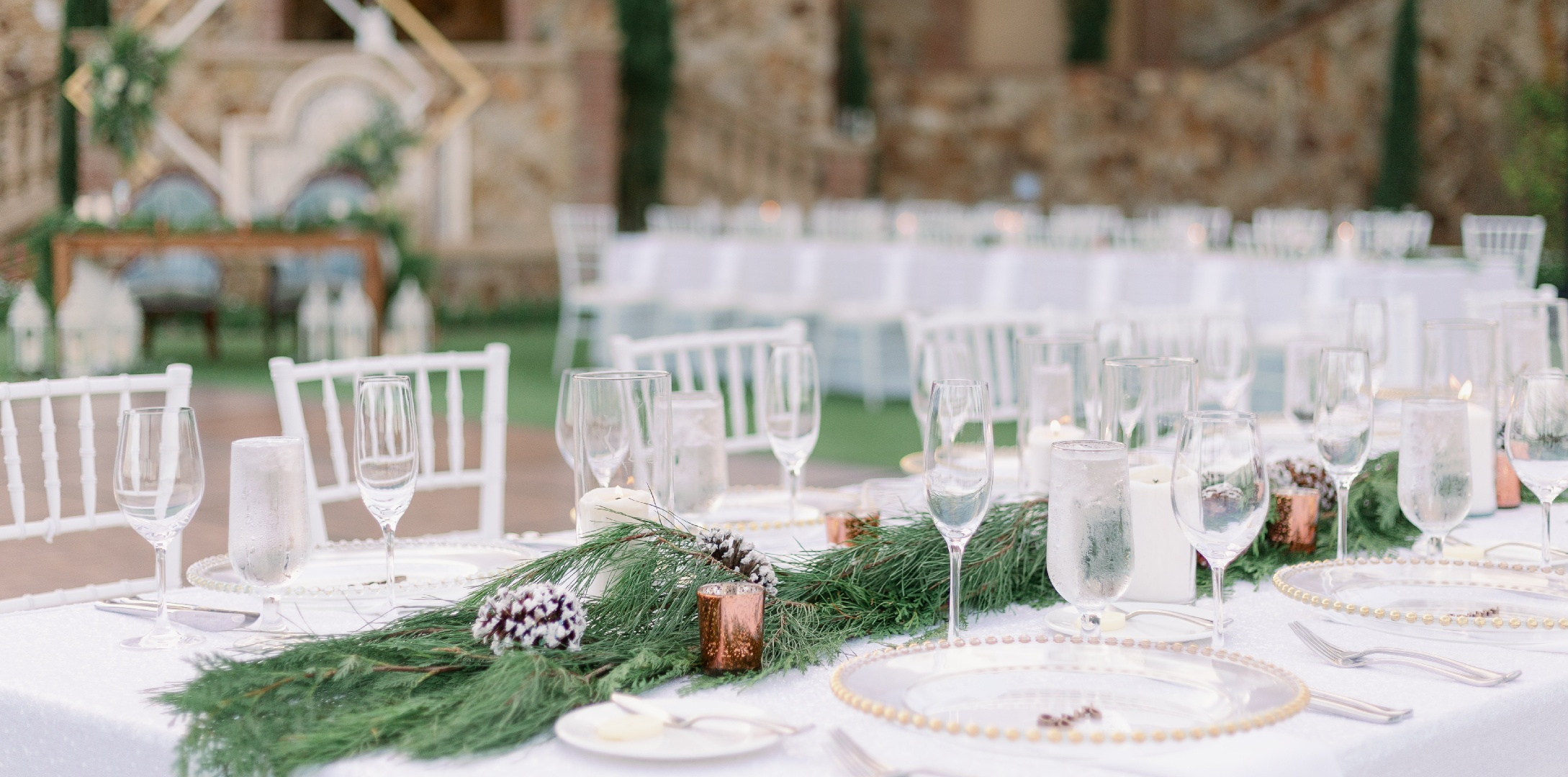 Elegant Grand Lawn dining table with greenery and white place settings at Bella Collina