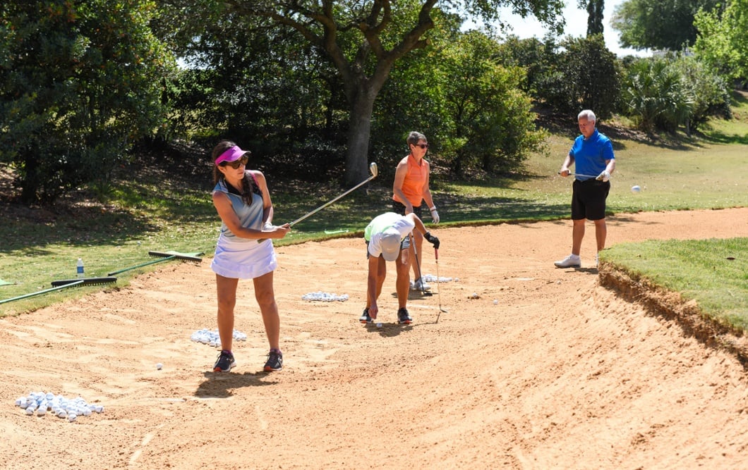 Group working on bunker shots with Bella Collina golf professional