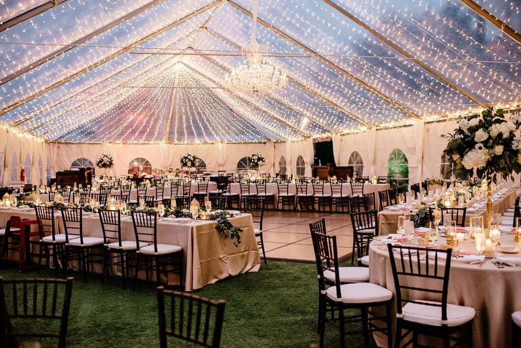 Tented Grand Lawn event with string lights and elegant dining tables at Bella Collina