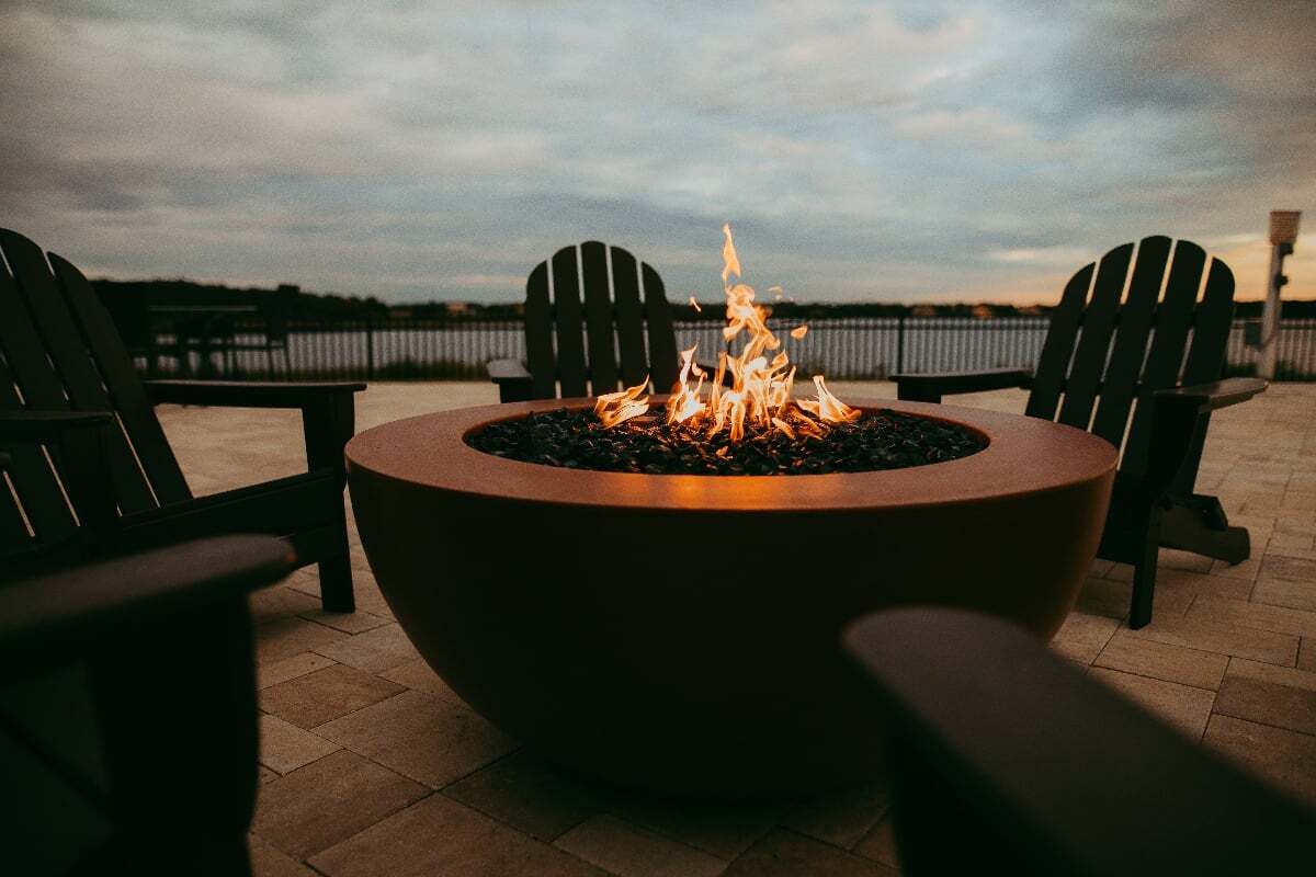 Outdoor fire pit with Adirondack chairs overlooking the water at Siena at Bella Collina