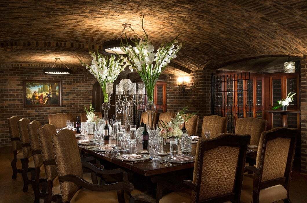 Formal dining table with tall floral centerpiece in the Wine Cellar at Bella Collina