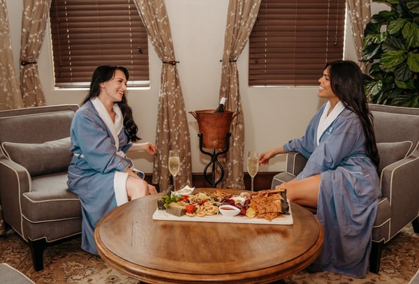 Two women enjoying appetizers and champagne at the Spa at Bella Collina
