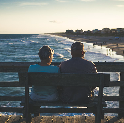 Couple sitting on bench at ocean