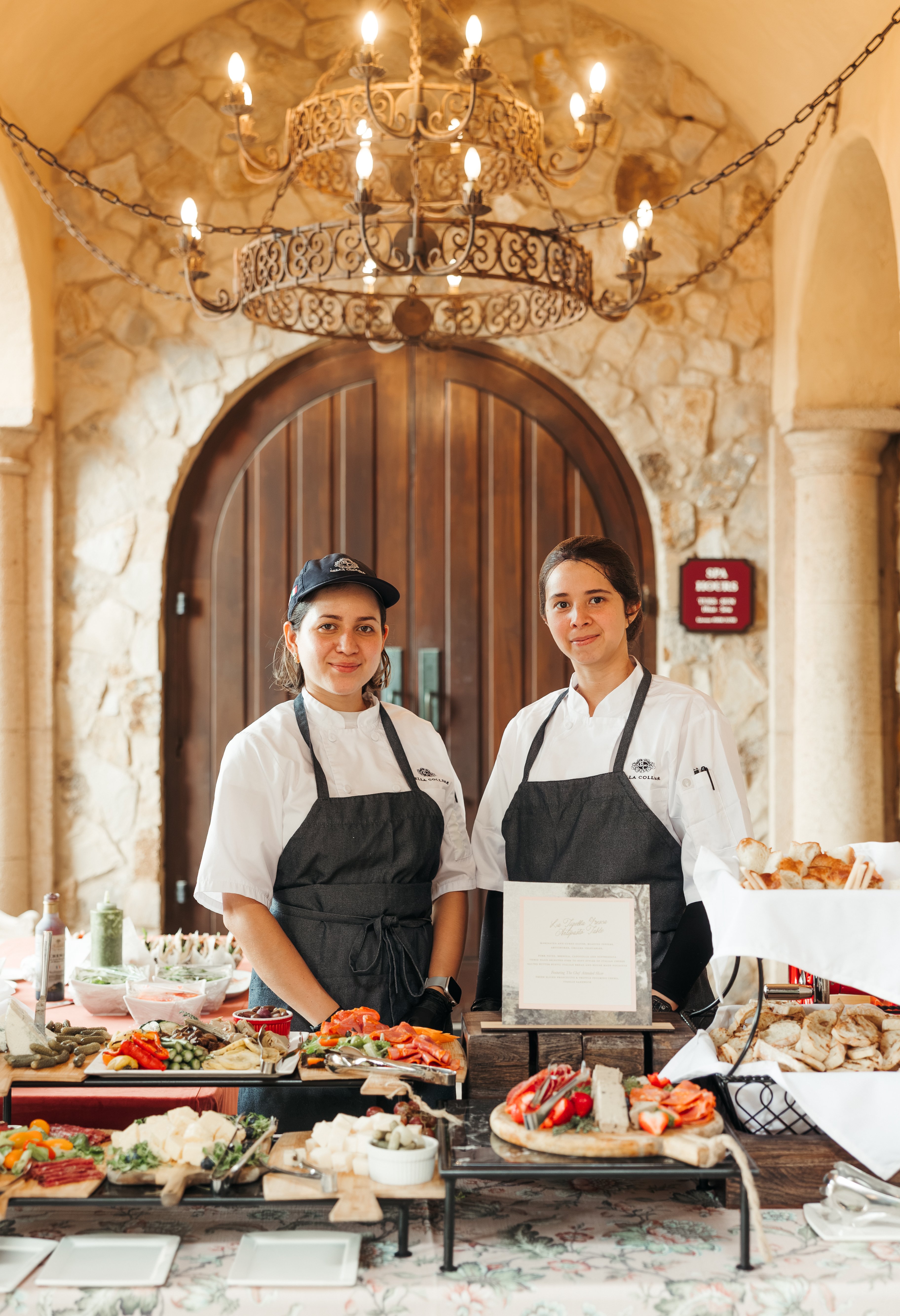 Culinary team members standing by food display at Bella Collina
