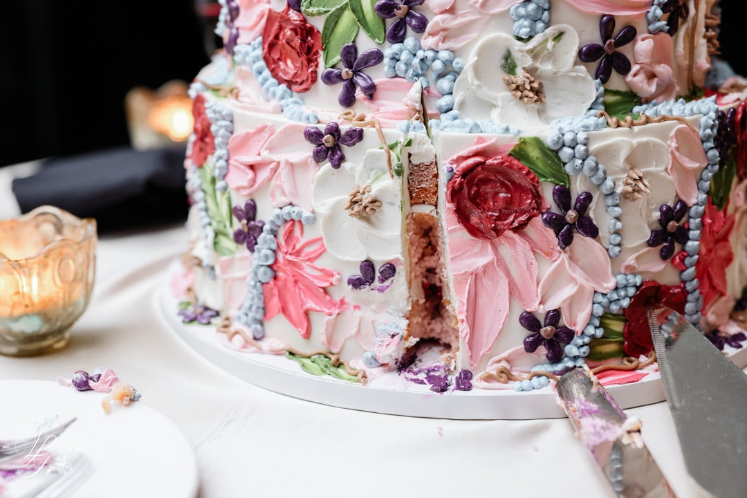 Colorful wedding cake with intricate floral and butterfly details at Bella Collina