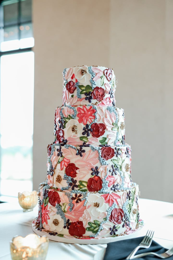 Three-tier wedding cake with colorful floral design at Bella Collina