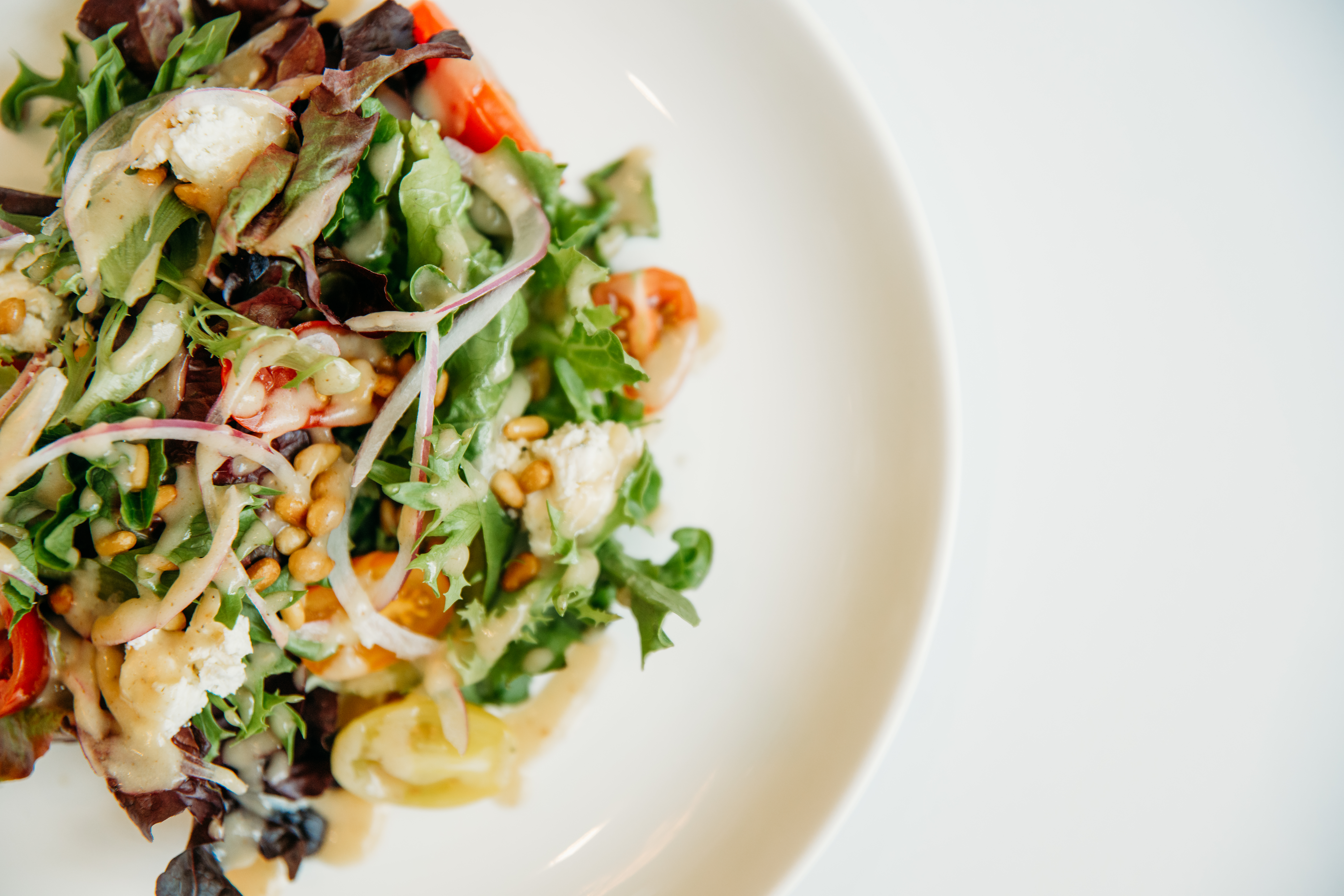 Fresh mixed green salad with vegetables and crumbled cheese served at a Bella Collina wedding reception